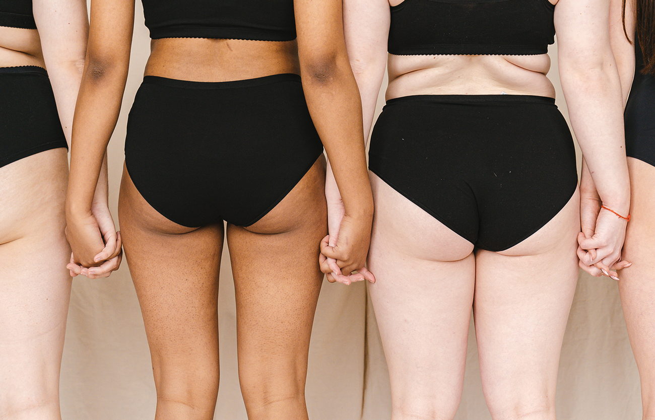 Women in underwear holding hands from behind