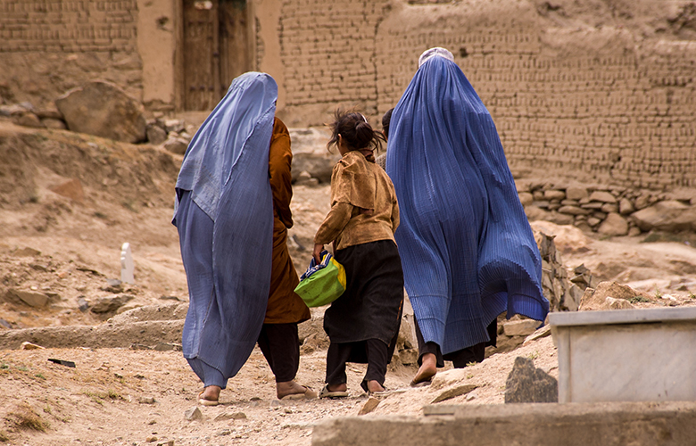 Three women wearing head scarves walking away